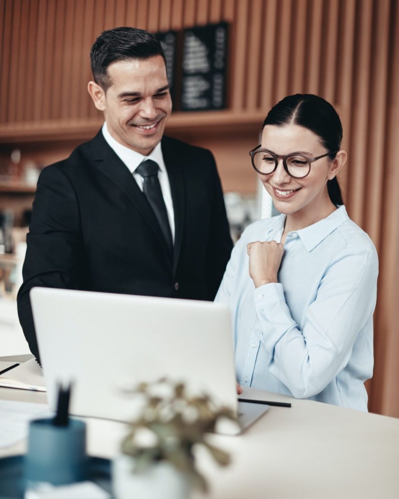 two-smiling-businesspeople-using-a-laptop-together-in-an-office-rk9dbdb0lnssluaovkpvagj12hpfib3yg41aaxlj40